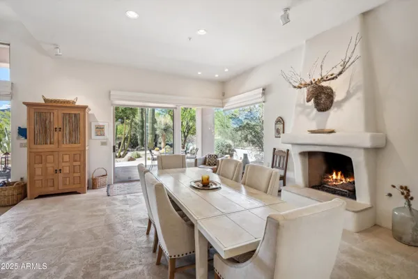 a living room with furniture a fireplace and a floor to ceiling window
