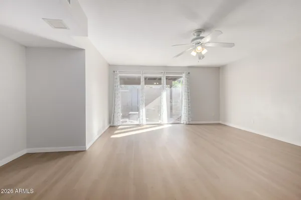 an empty room with wooden floor and windows