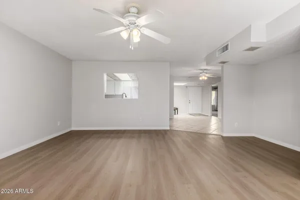 an empty room with wooden floor and windows