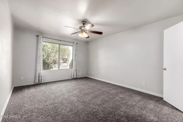 an empty room with windows and fan