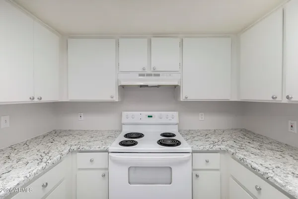 a kitchen with granite countertop white cabinets and white appliances