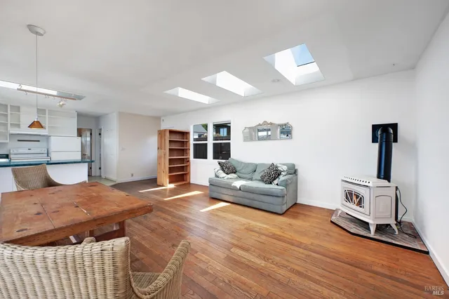 a living room with furniture a large window and wooden floor
