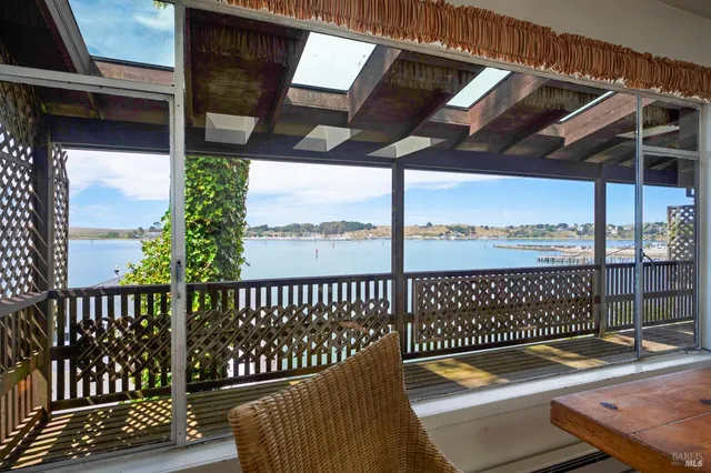 a view of a balcony with wooden floor and outdoor seating
