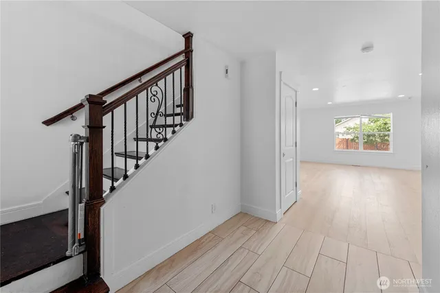 a view of hallway with wooden floor and stairs