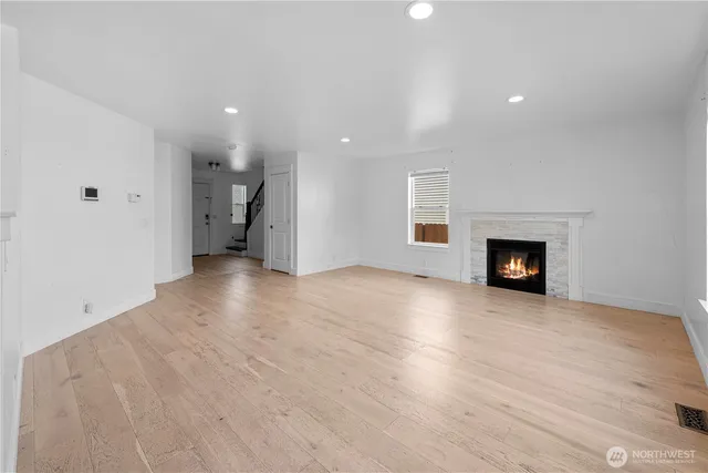 an empty room with wooden floor and fireplace