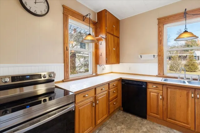 a view of a hallway with wooden floor and a bathroom