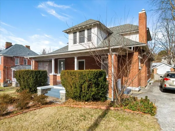 a front view of a house with a yard covered with snow