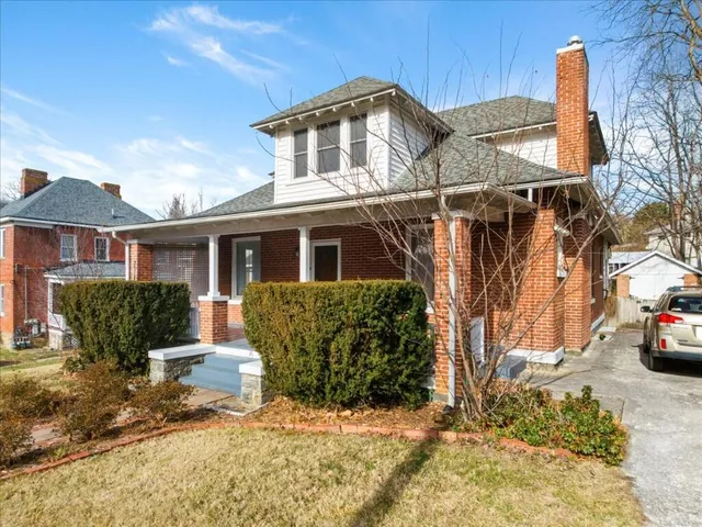 a front view of a house with a yard covered with snow
