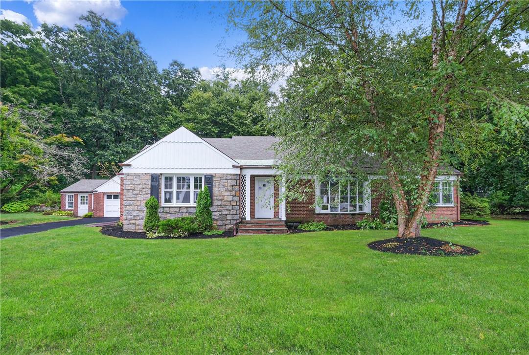 61 Oregon Road Cortlandt Manor, NY 10567 - Photo 1 of 1 a front view of a house with a garden and trees