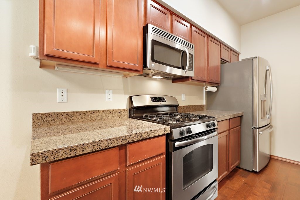 21532 11th Court Southeast Bothell, WA 98021 - Photo 11 of 36 a kitchen with stainless steel appliances granite countertop a stove microwave sink and refrigerator