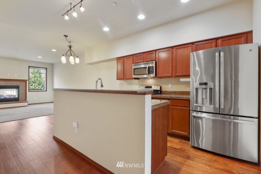 21532 11th Court Southeast Bothell, WA 98021 - Photo 13 of 36 a kitchen with stainless steel appliances granite countertop a refrigerator sink and cabinets