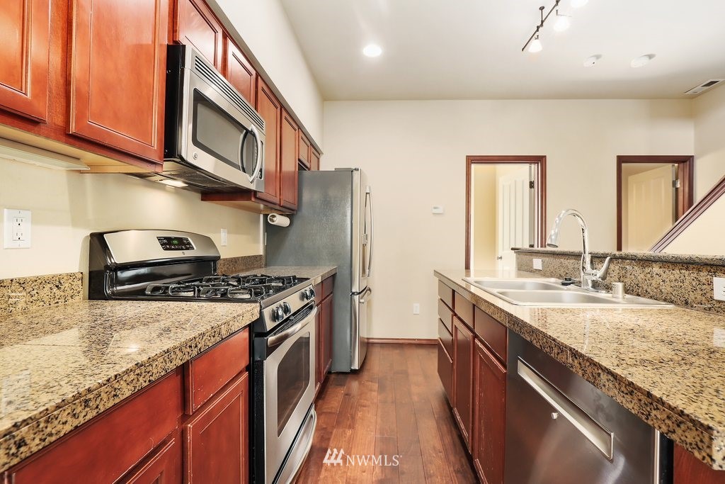 21532 11th Court Southeast Bothell, WA 98021 - Photo 10 of 36 a kitchen with stainless steel appliances granite countertop a sink stove and refrigerator
