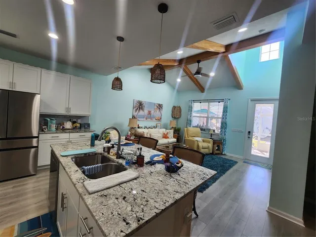 a kitchen with a sink a stove and chairs