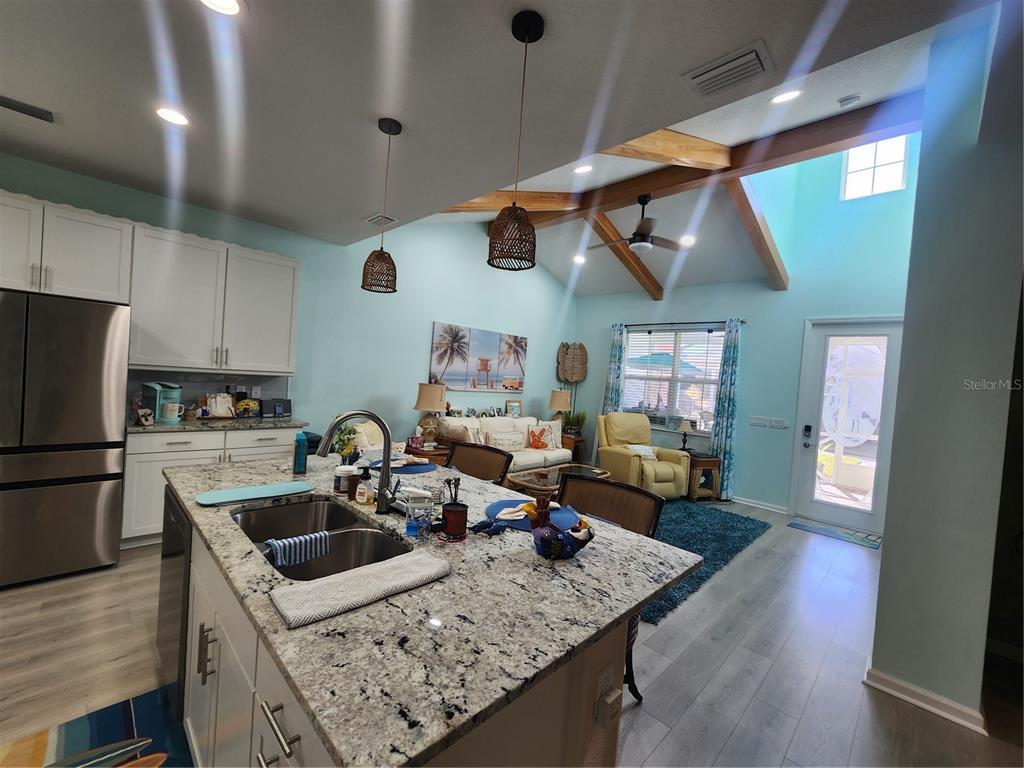 218 Ocean Hammock Loop Daytona Beach, FL 32124 - Photo 3 of 13 a kitchen with a sink a stove and chairs
