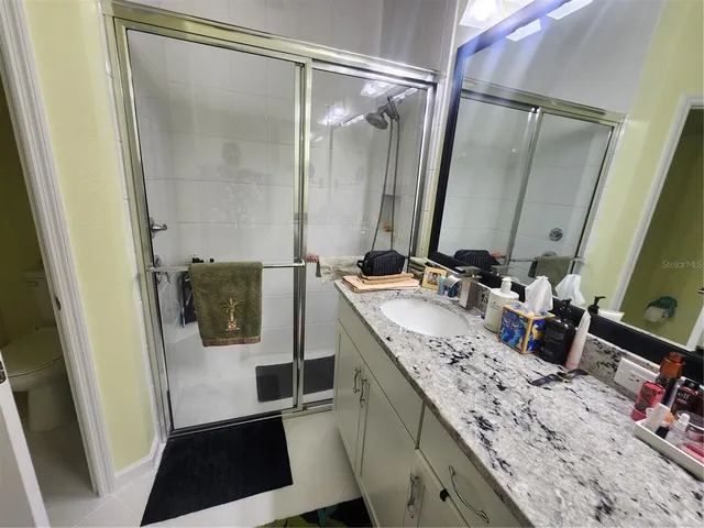 a bathroom with a sink and mirror with bathtub