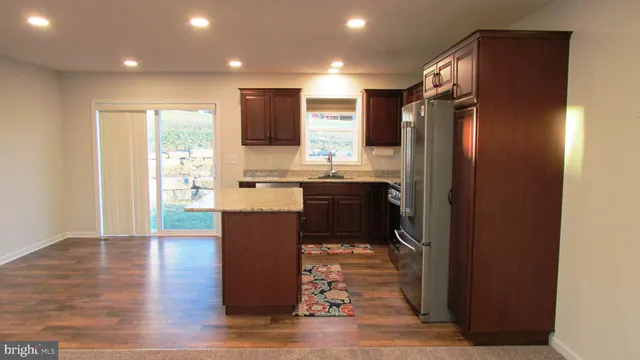 a kitchen with a refrigerator and a stove top oven
