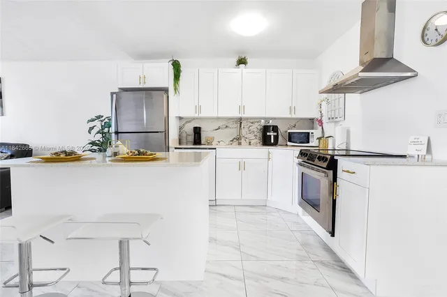 a kitchen with stainless steel appliances a refrigerator sink and cabinets