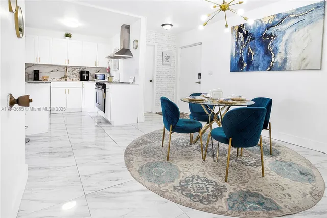 a view of kitchen with stainless steel appliances kitchen island dining table and chairs