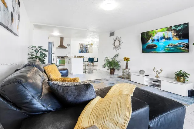 a living room with furniture and painting on the wall