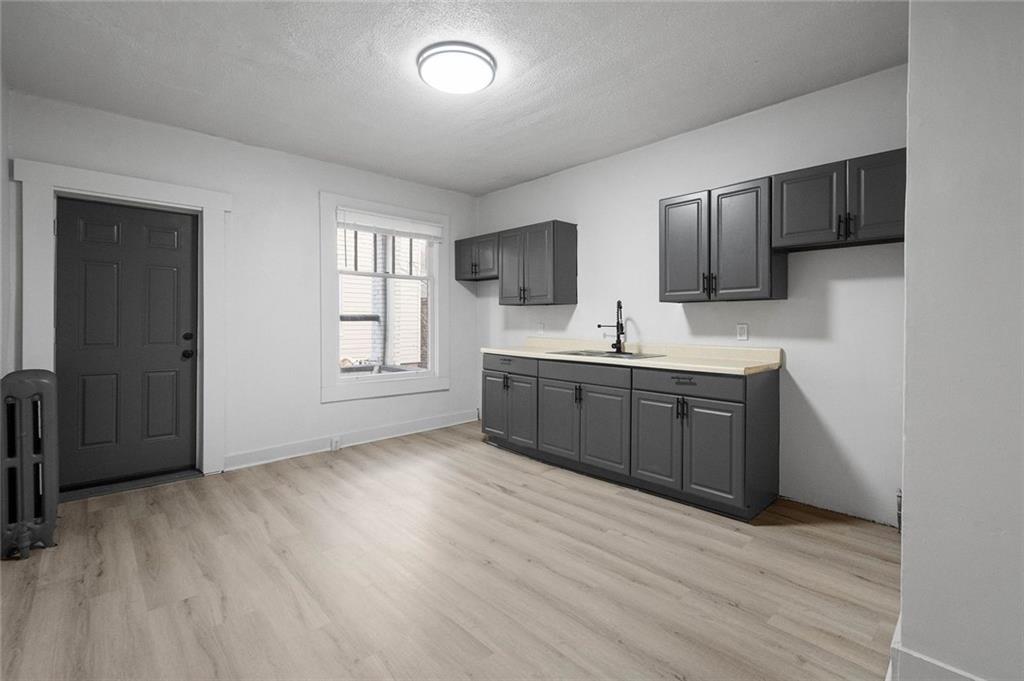 306 Park Road Ambridge, PA 15003 - Photo 9 of 43 a view of a kitchen with a sink dishwasher and wooden floor