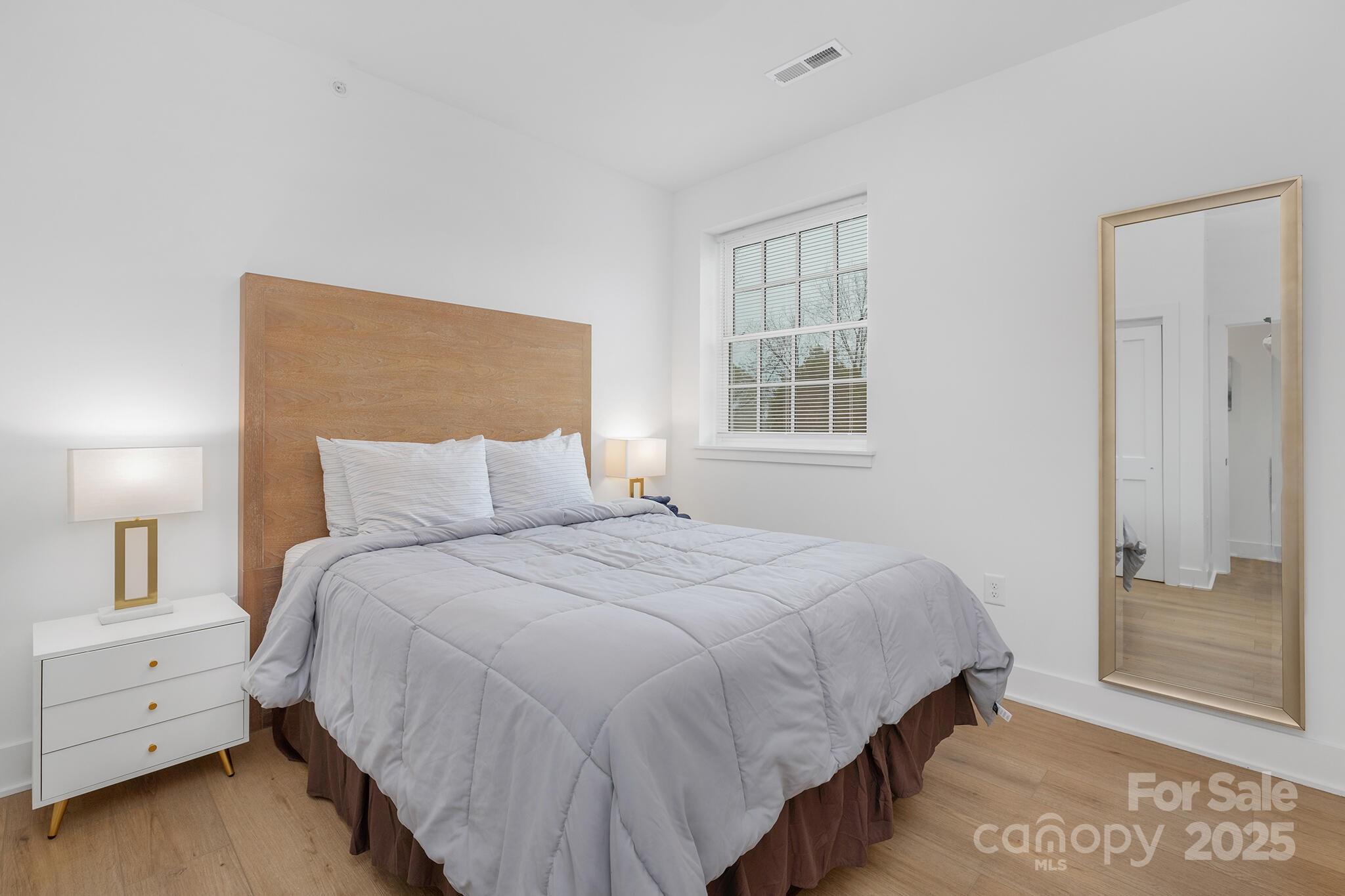 203 Grandin Road, Unit 2 Charlotte, NC 28208 - Photo 11 of 23 a bedroom with a bed and a night stand