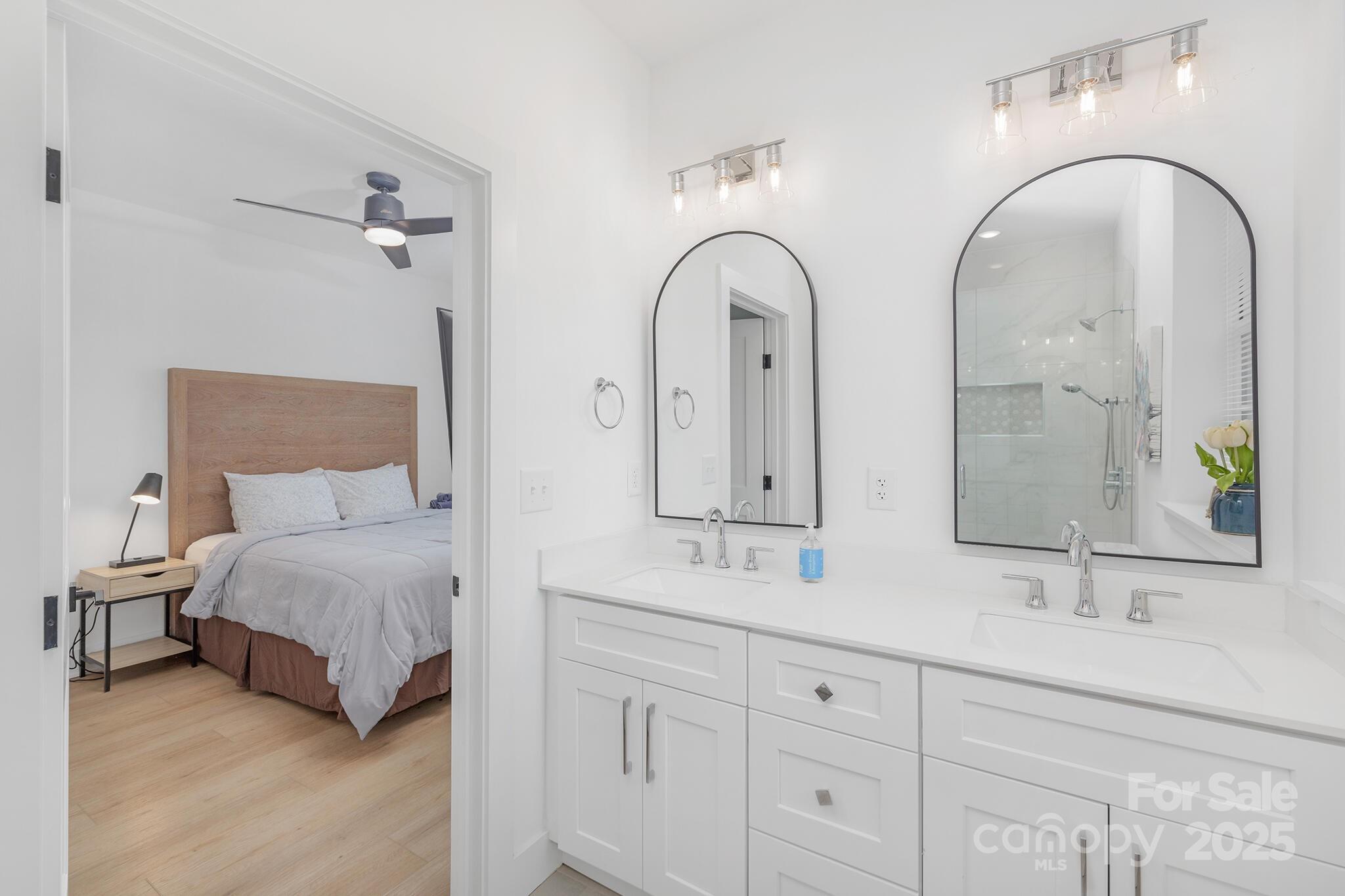 203 Grandin Road, Unit 2 Charlotte, NC 28208 - Photo 16 of 23 a spacious bedroom with a bed a mirror and wall painting