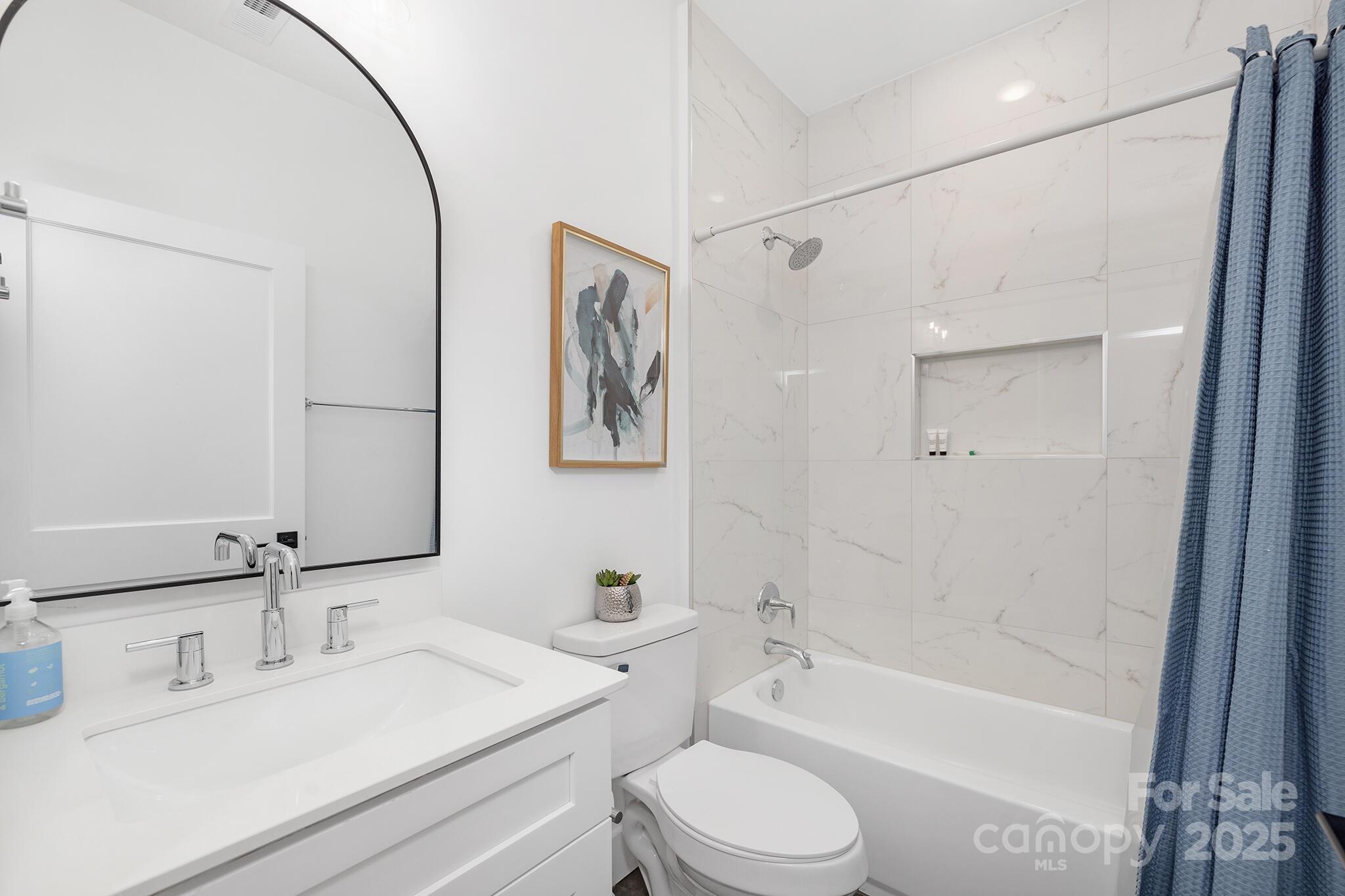 203 Grandin Road, Unit 2 Charlotte, NC 28208 - Photo 17 of 23 a bathroom with a bathtub shower sink vanity mirror and toilet