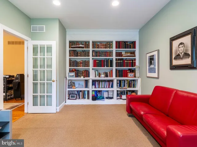 a living room with furniture and a book shelf