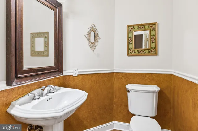 a bathroom with a toilet a sink and mirror
