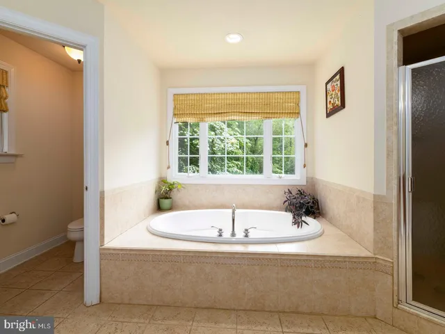 a bathroom with bathtub and window