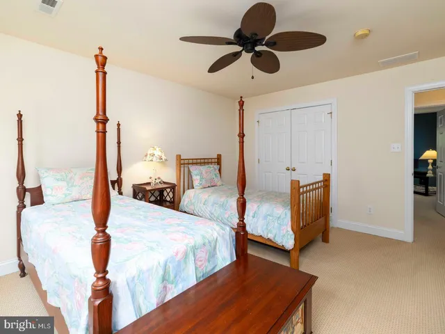 a bedroom with a bed a ceiling fan and a dresser