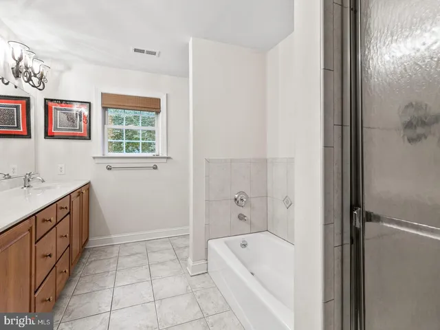 a bathroom with a tub sink and mirror