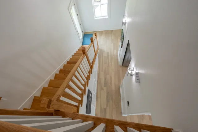 a view of a hallway with wooden floor and a living room