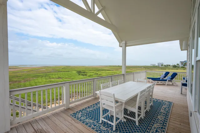 a view of a balcony with dining space and ocean view