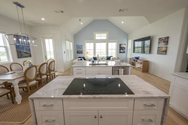a kitchen with granite countertop a sink white cabinets and wooden floor