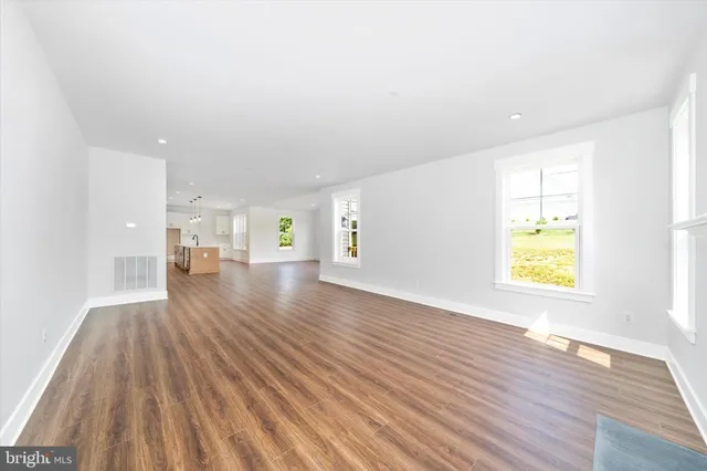 a view of empty room with wooden floor and window