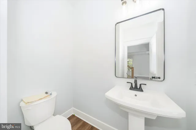 a bathroom with a toilet a sink and mirror