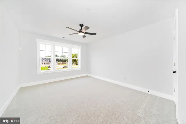 an empty room with a ceiling fan and a window