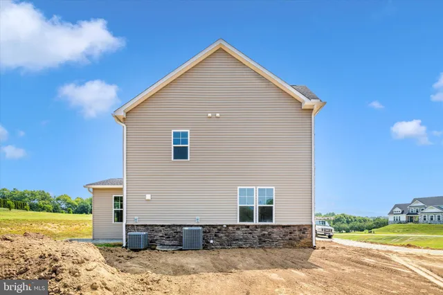 a front view of a house with a yard and lake view