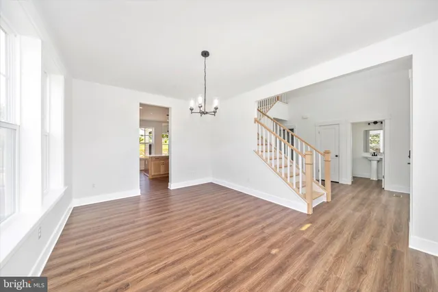 a view of a hallway with wooden floor and staircase