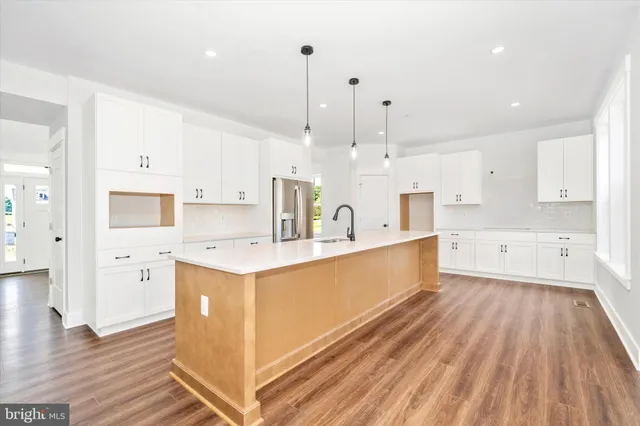 a large kitchen with stainless steel appliances kitchen island granite countertop a stove a sink and a refrigerator