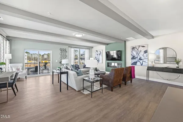 a living room with furniture dining area and a flat screen tv