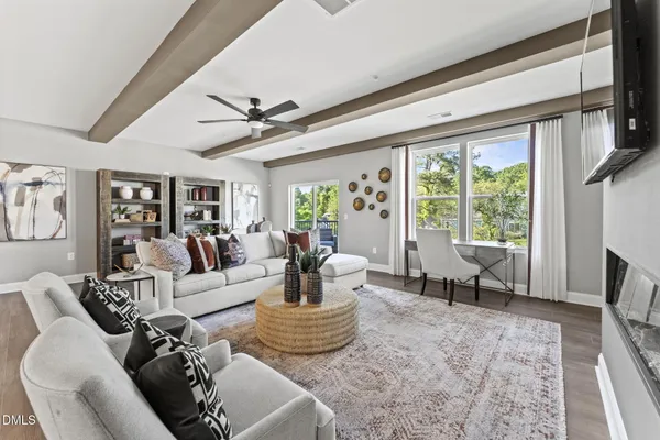 a living room with furniture fireplace and a large window