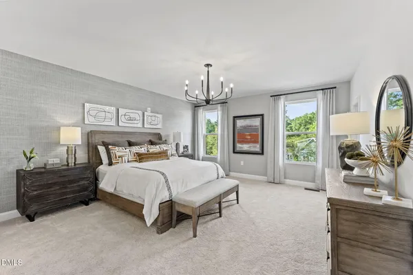 a spacious bedroom with a bed a chandelier and a large window