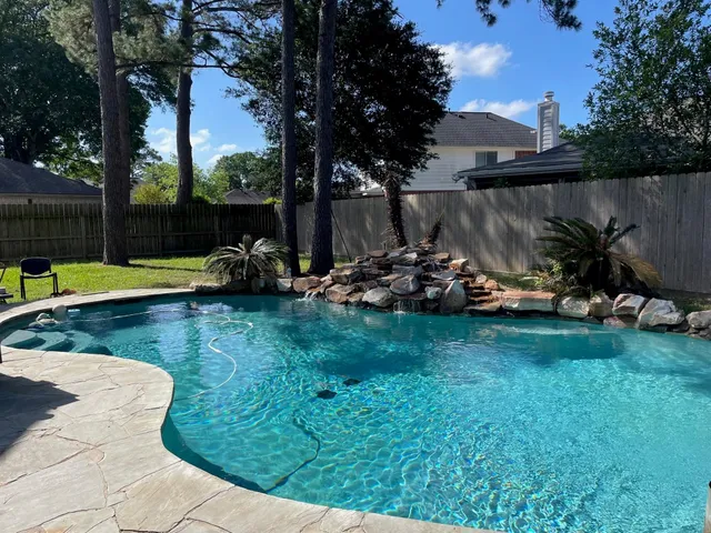 a view of a backyard with lawn chairs and a fire pit