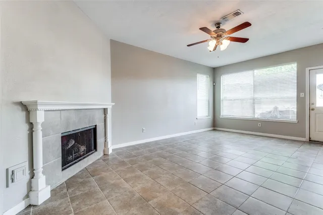 an empty room with windows and fireplace