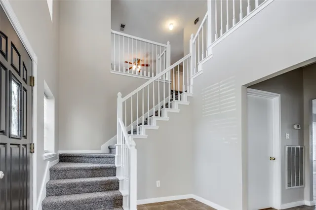 a view of staircase with lots of frames on wall and a window