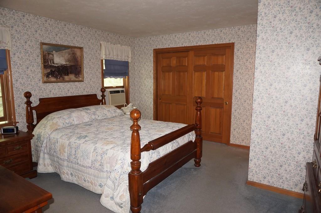 522 Leadmine Road Sturbridge, MA 01566 - Photo 15 of 33 a bed sitting in a bedroom next to a bathroom