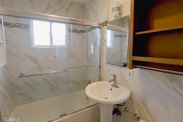 a bathroom with a sink a shower and a mirror