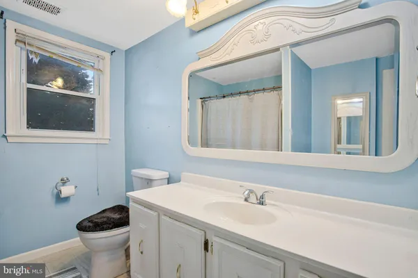 a bathroom with a toilet a sink and mirror